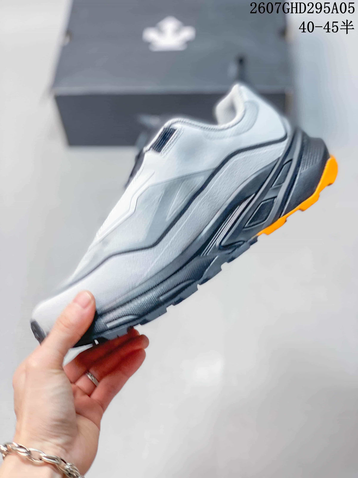 Side profile of the white and gray sneaker showing layered panels, a black midsole, and orange outsole accents; style code 2607GHD295A05 and size range 40–45 are overlaid.