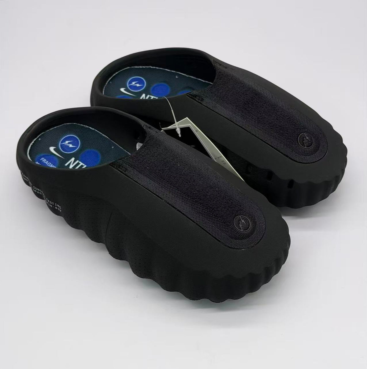 Top three-quarter view of the pair showing the open heel, textured uppers and blue footbed graphics.
