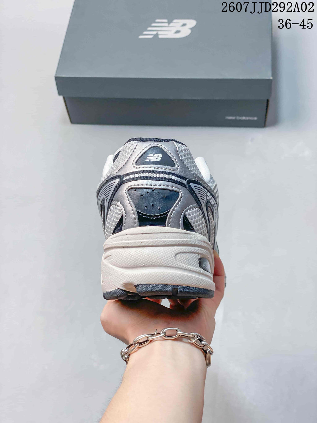 Rear view of the white and grey New Balance 509 sneaker showing the layered heel panels and thick sole.