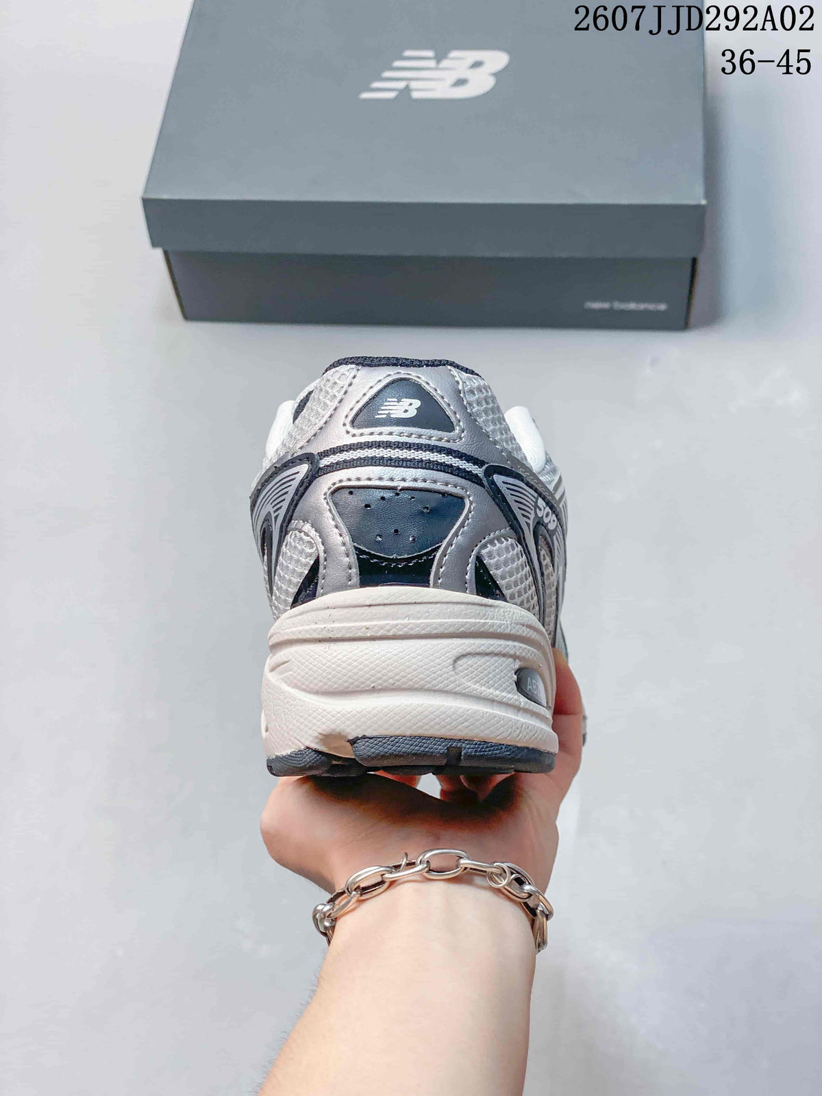 Rear view of the white and grey New Balance 509 sneaker showing the layered heel panels and thick sole.