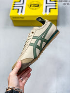 Side profile of the cream sneaker showing green side stripes, brown toe overlay, low-top construction and gum-colored outsole.