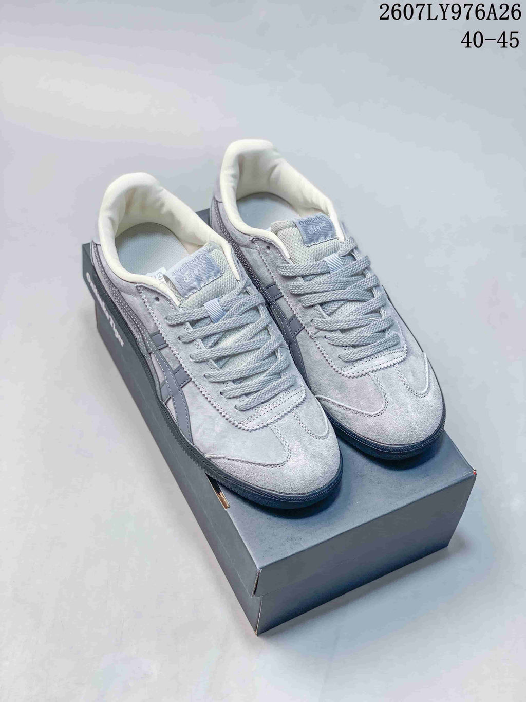 Light gray Onitsuka Tiger Tokuten sneakers with darker gray side stripes displayed on a shoebox.