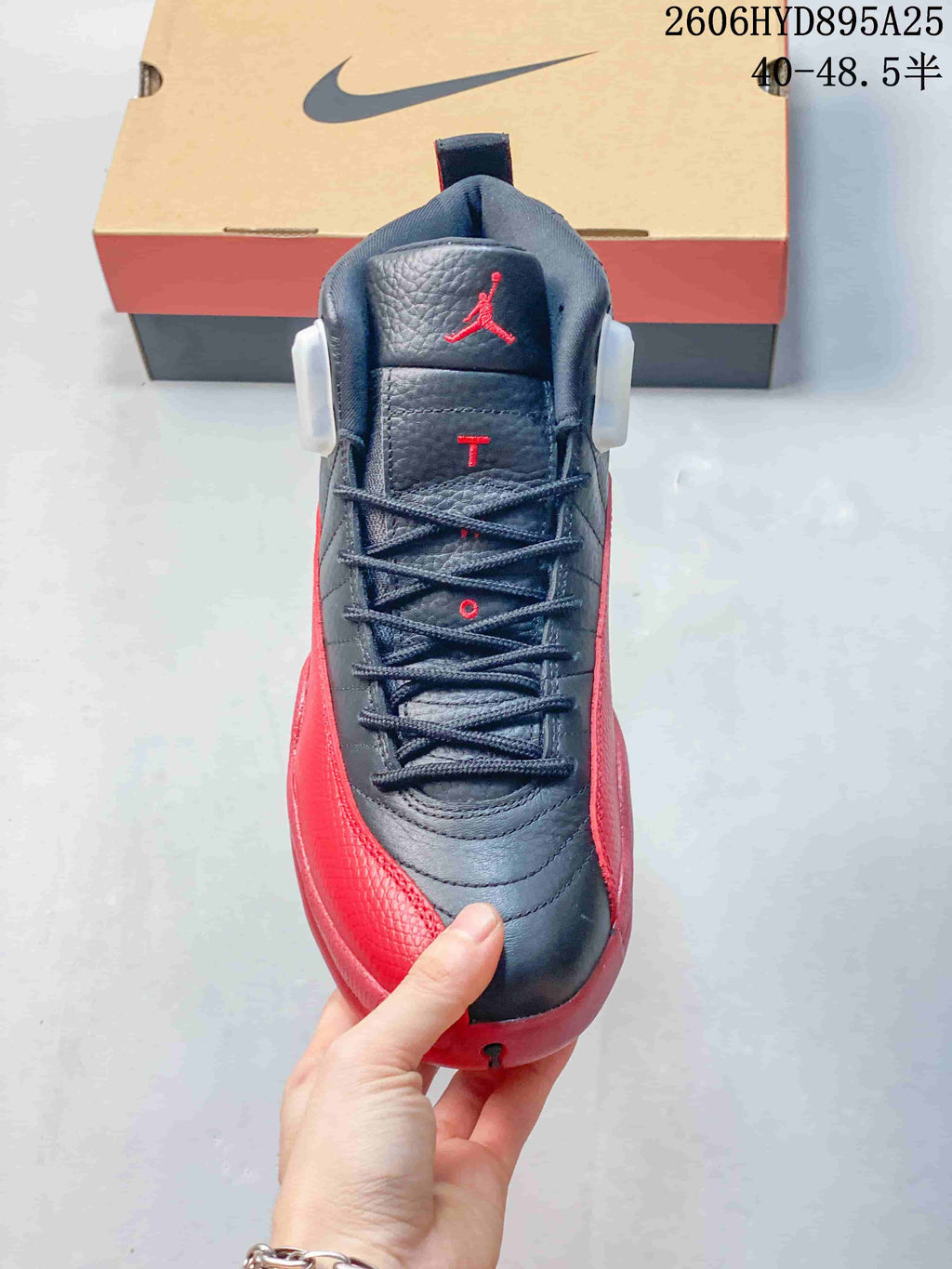 Front view of a black and red Jordan Air Jordan 12 sneaker with laces