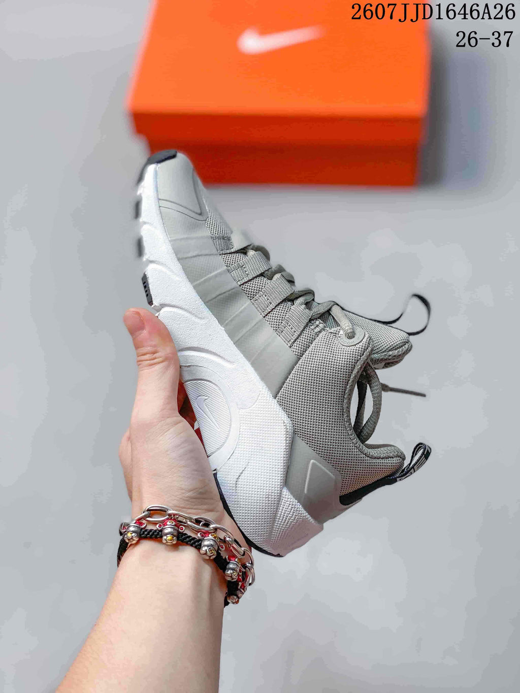 Side profile of the gray and white low-top Nike Free Metcon 7 children's sneaker with layered panels and a textured upper.