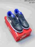 Pair of black, white, and blue Nike SB Dunk Low Pro sneakers displayed on a red shoebox.