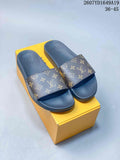 Pair of brown-and-gold monogram slide sandals displayed on a yellow box; size range 36-45 and style code 2607YD1649A19 are visible.