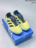 Pair of yellow and black Adidas Zponge low-top sneakers displayed on a blue Adidas shoe box.