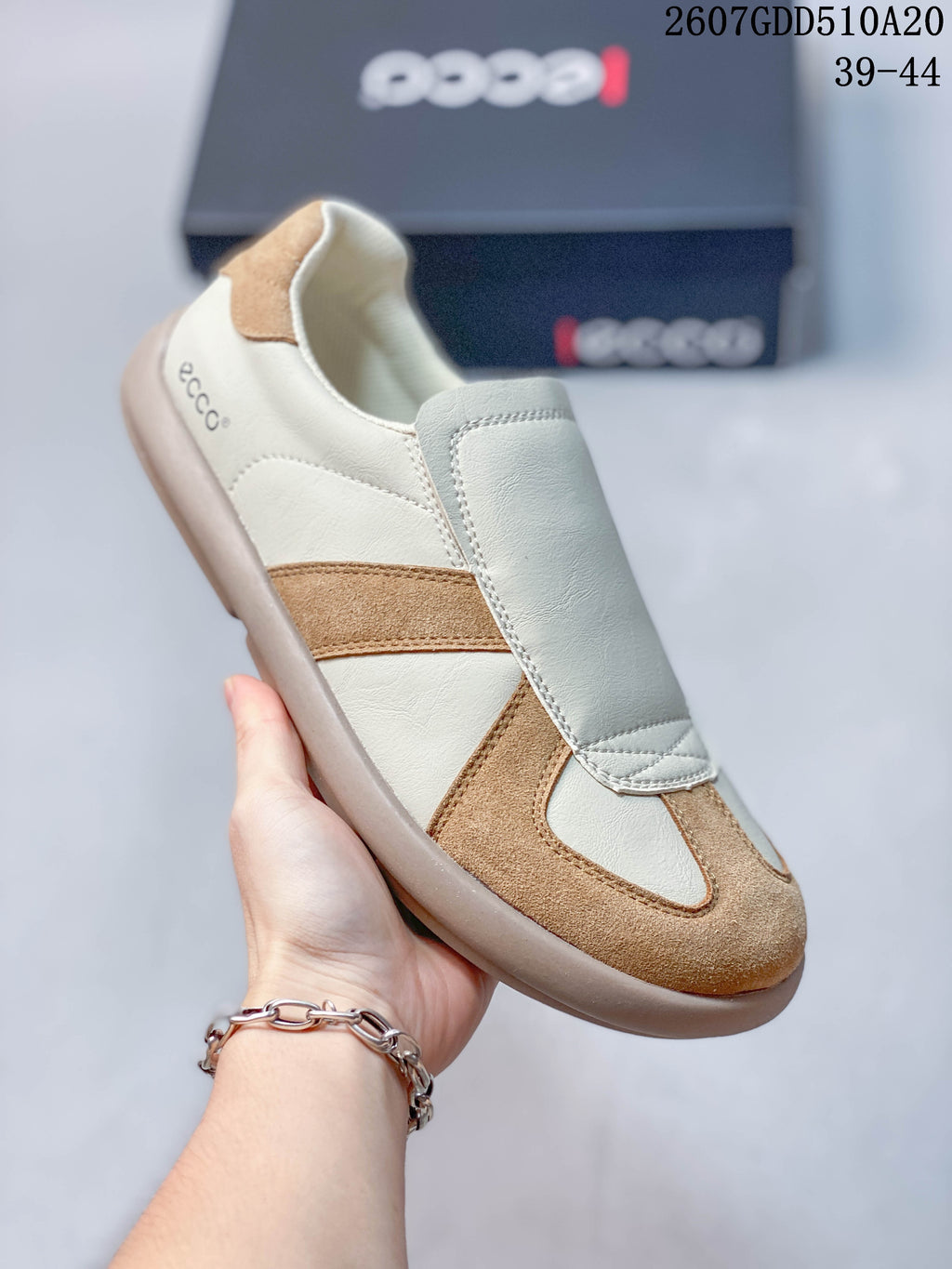 Angled side view of a cream and tan ECCO sneaker with visible branding at the heel.