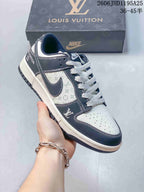Close view of a white and navy monogram-print low-top sneaker with light patterned laces.
