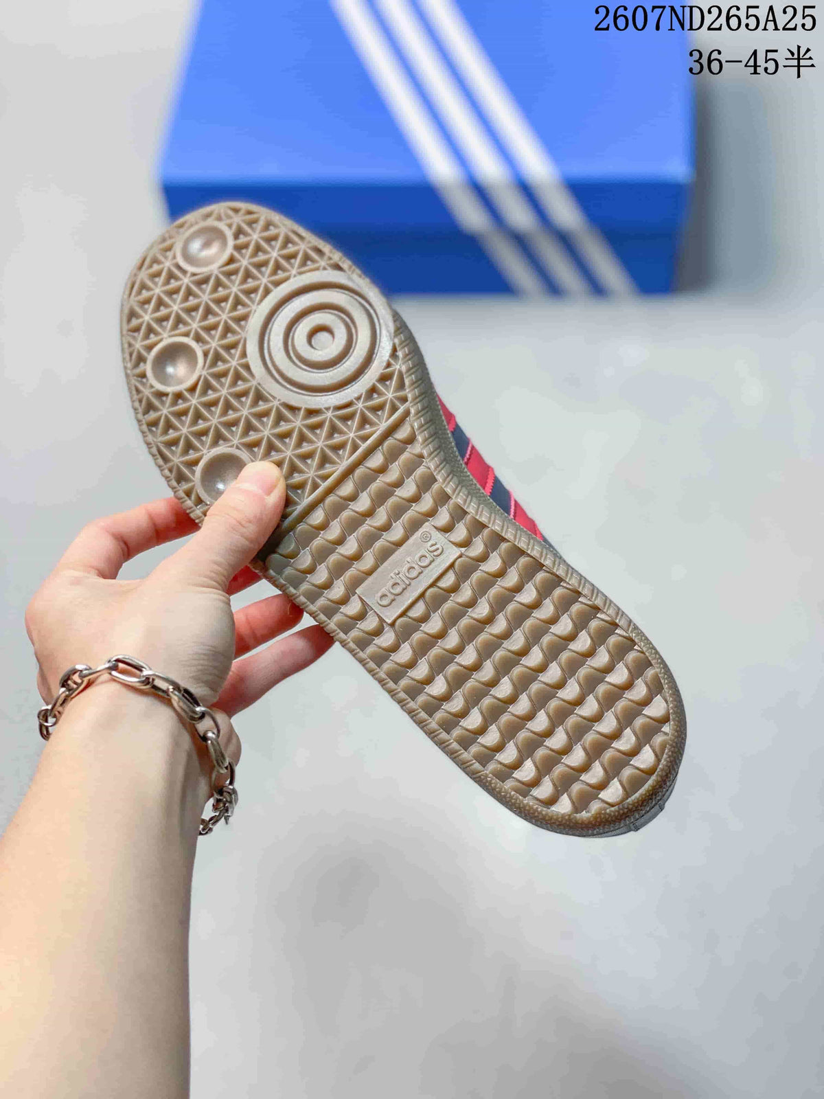 Close view of the patterned gum-colored rubber outsole with circular traction details and Adidas branding.