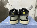 Rear view of black Nike basketball shoes with yellow heel details and pale soles