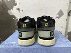 Rear view of black Nike basketball shoes with yellow heel details and pale soles