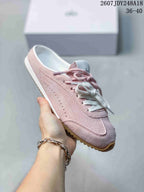 Side view of a pink alo mule sneaker showing the open heel, perforated side panel and gum-colored outsole.