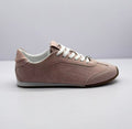 Side view of a pink low-top sneaker with white laces and a brown outsole.