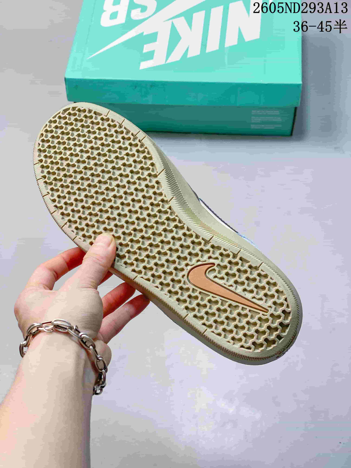 Close view of the sneaker outsole showing a honeycomb-like textured tread and gum-toned rubber.