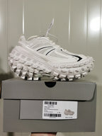 Side view of the sneaker resting on its box; the box label shows style 68561 W2RAA 9110, Eggshell/Black, and size C 39.