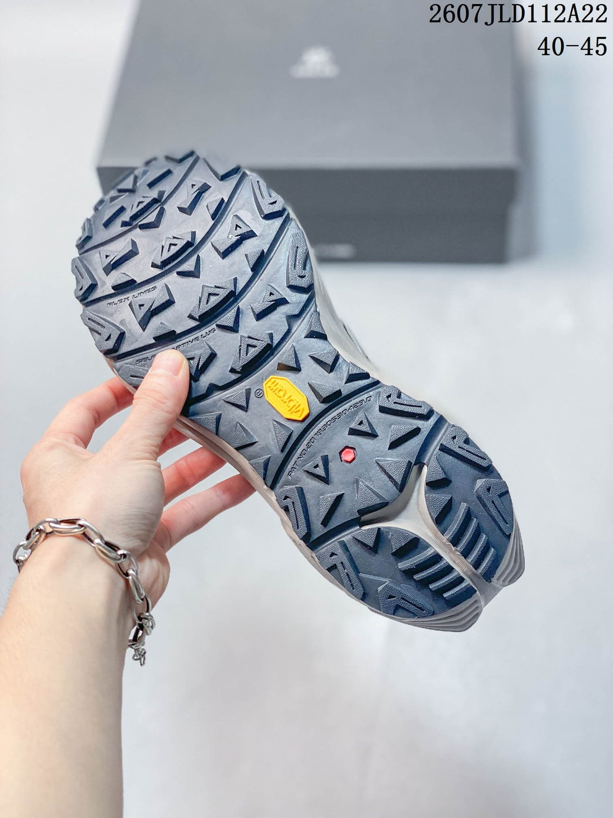 Close view of the trail shoe outsole showing an aggressive lug pattern and a visible Vibram mark.