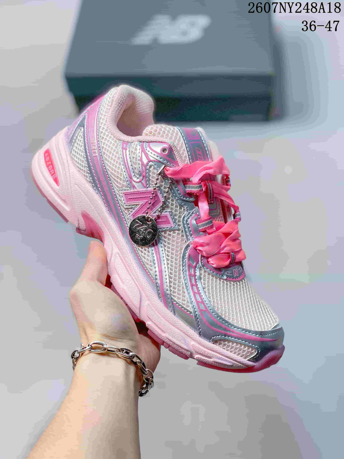 White, silver, and bright pink New Balance 740 sneaker with pink laces and accents.