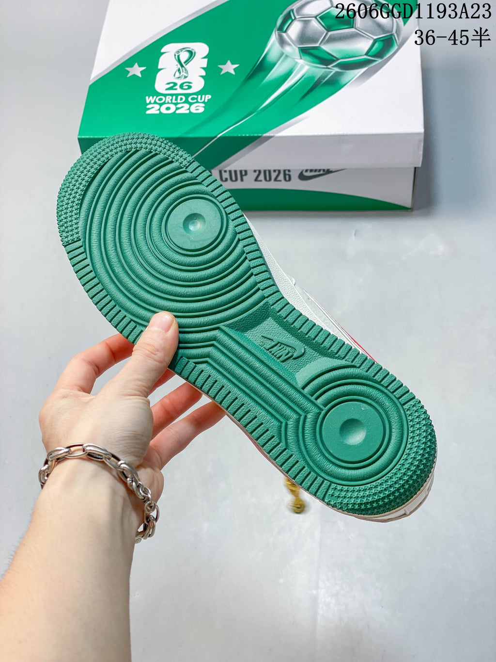 Green outsole of a white sneaker shown beside a green-and-white 2026 World Cup-themed box.