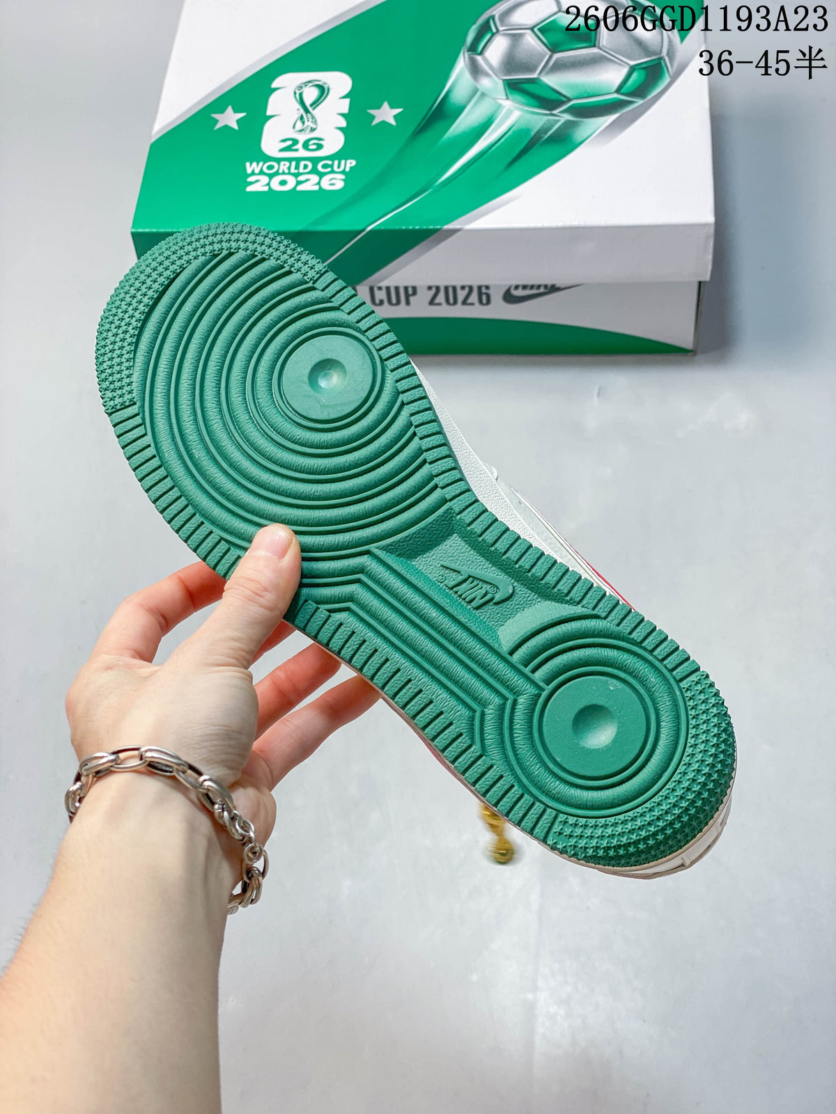 Green outsole of a white sneaker shown beside a green-and-white 2026 World Cup-themed box.
