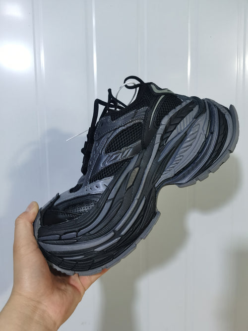 Side view of the dark grey 1011 sneaker showing mesh panels, layered overlays and a sculpted sole.