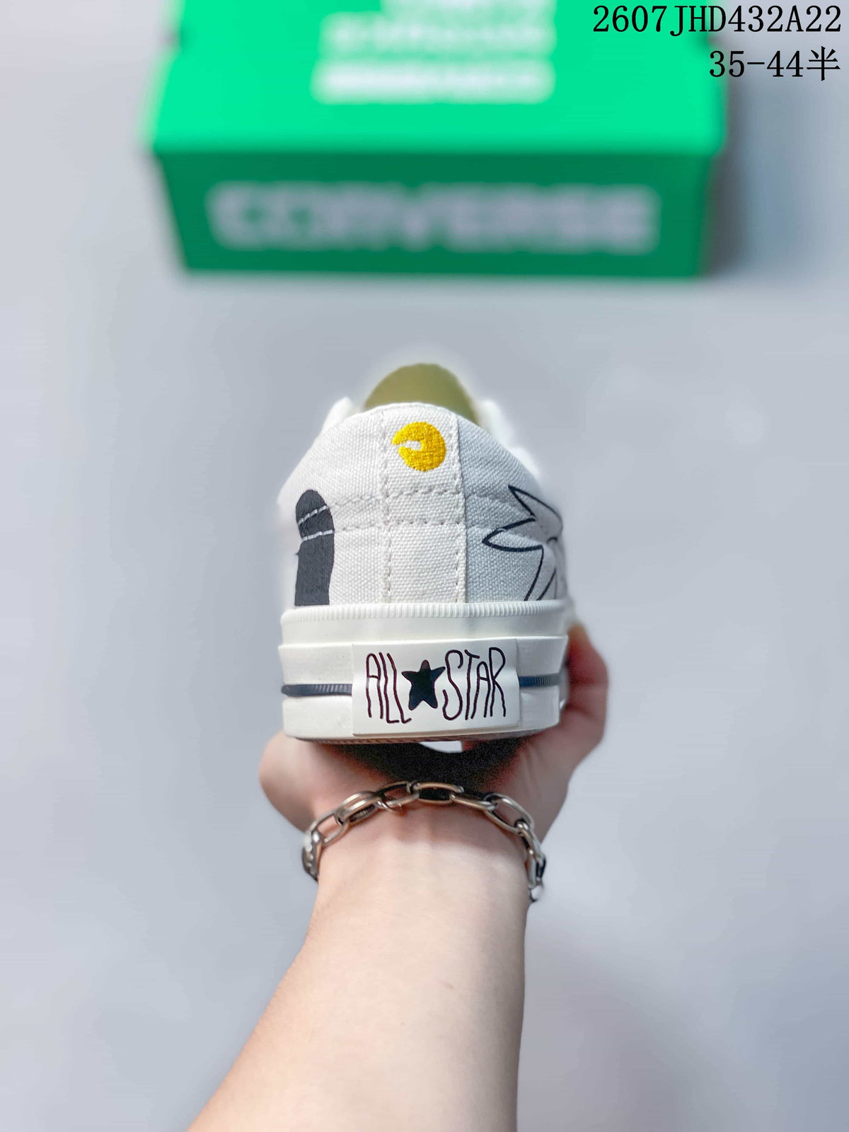 Rear view of the white sneaker showing the All Star heel label and illustrated side graphics.