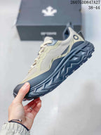 Side profile of the beige, navy and black low-top hiking sneaker with layered panels and a raised patterned outsole; overlay text shows 2607GDD847A27 and size range 38–44.