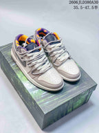 Pair of pink and gray low-top sneakers with purple and orange collar lining, displayed on a patterned shoe box.