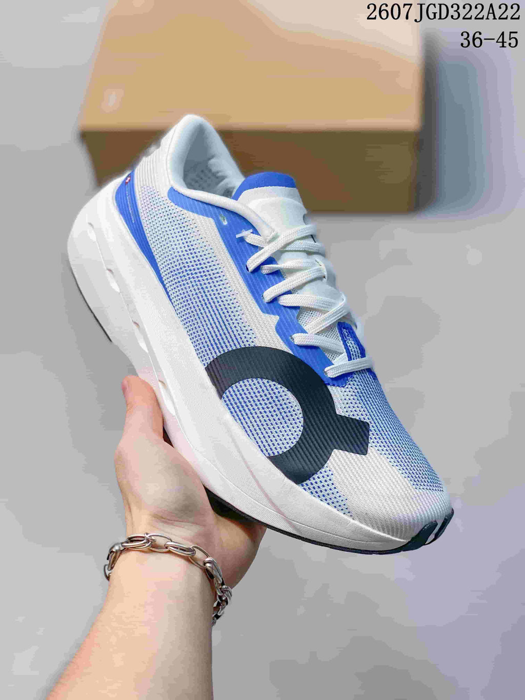 Angled side view of the white and blue On running shoe, showing the breathable-looking patterned upper, lace closure and layered sole.