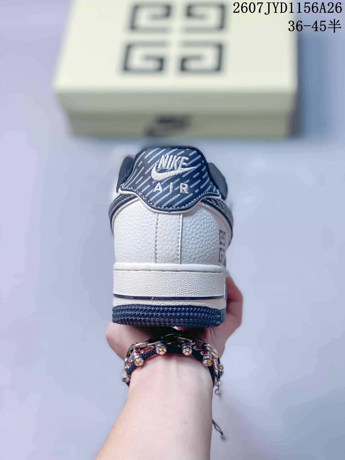 Rear view of the white and navy sneaker showing the padded collar, heel stitching, Nike Air tongue branding, and printed heel details.