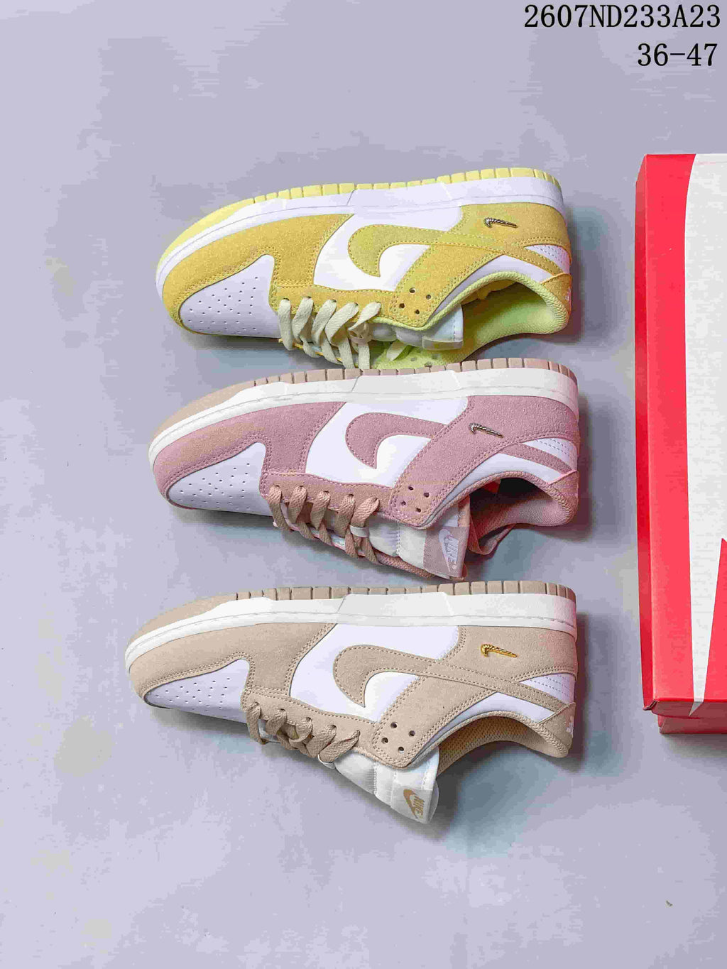 Top-down comparison of the yellow-gold, pink, and tan colorways beside a red shoebox.