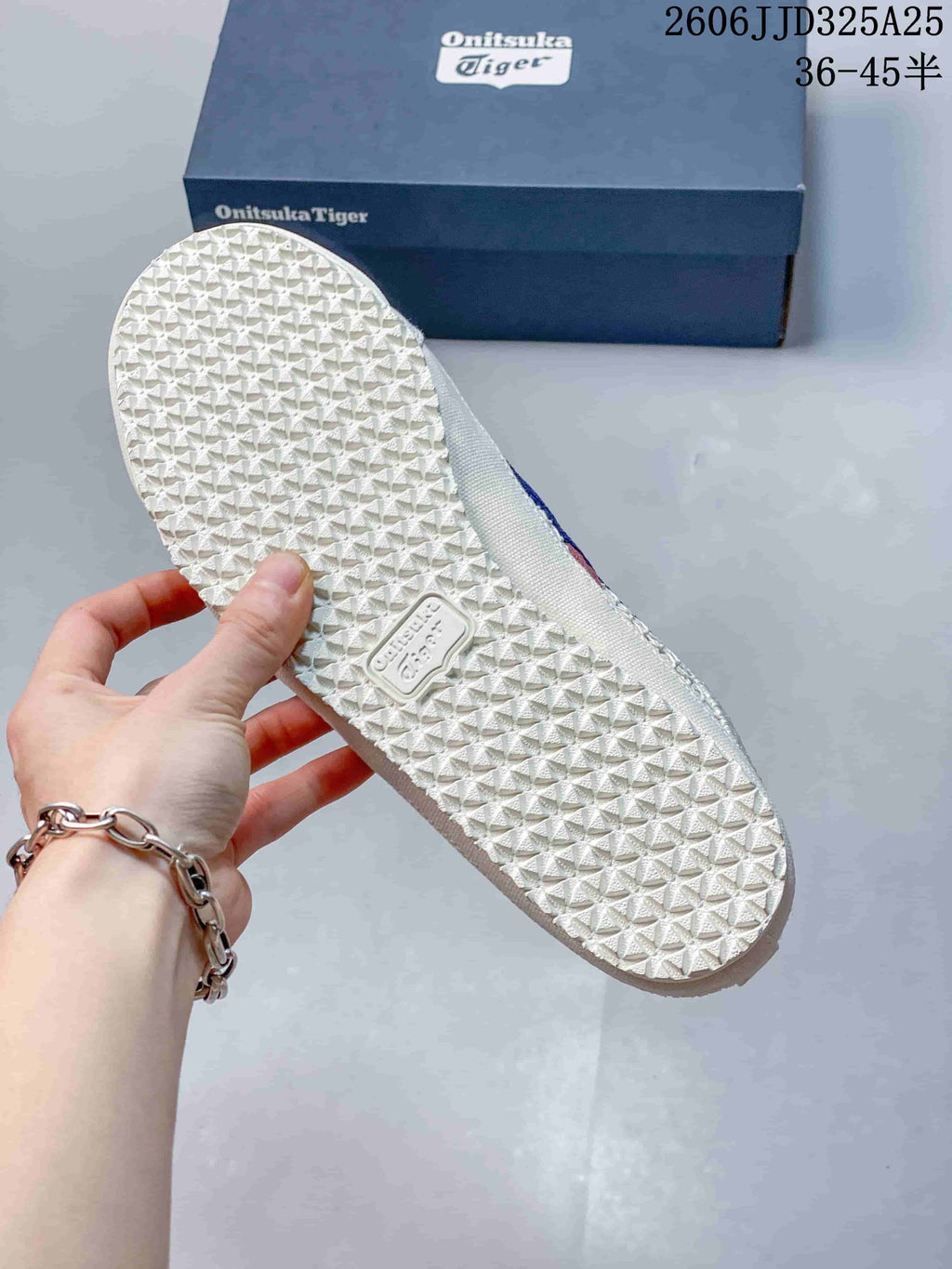 Underside of the sneaker showing the textured rubber outsole and branded outsole insert.