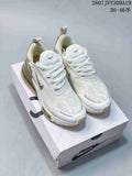 Pair of white and light cream Nike Air Max 270 sneakers displayed on a shoebox, with the heel air units visible.