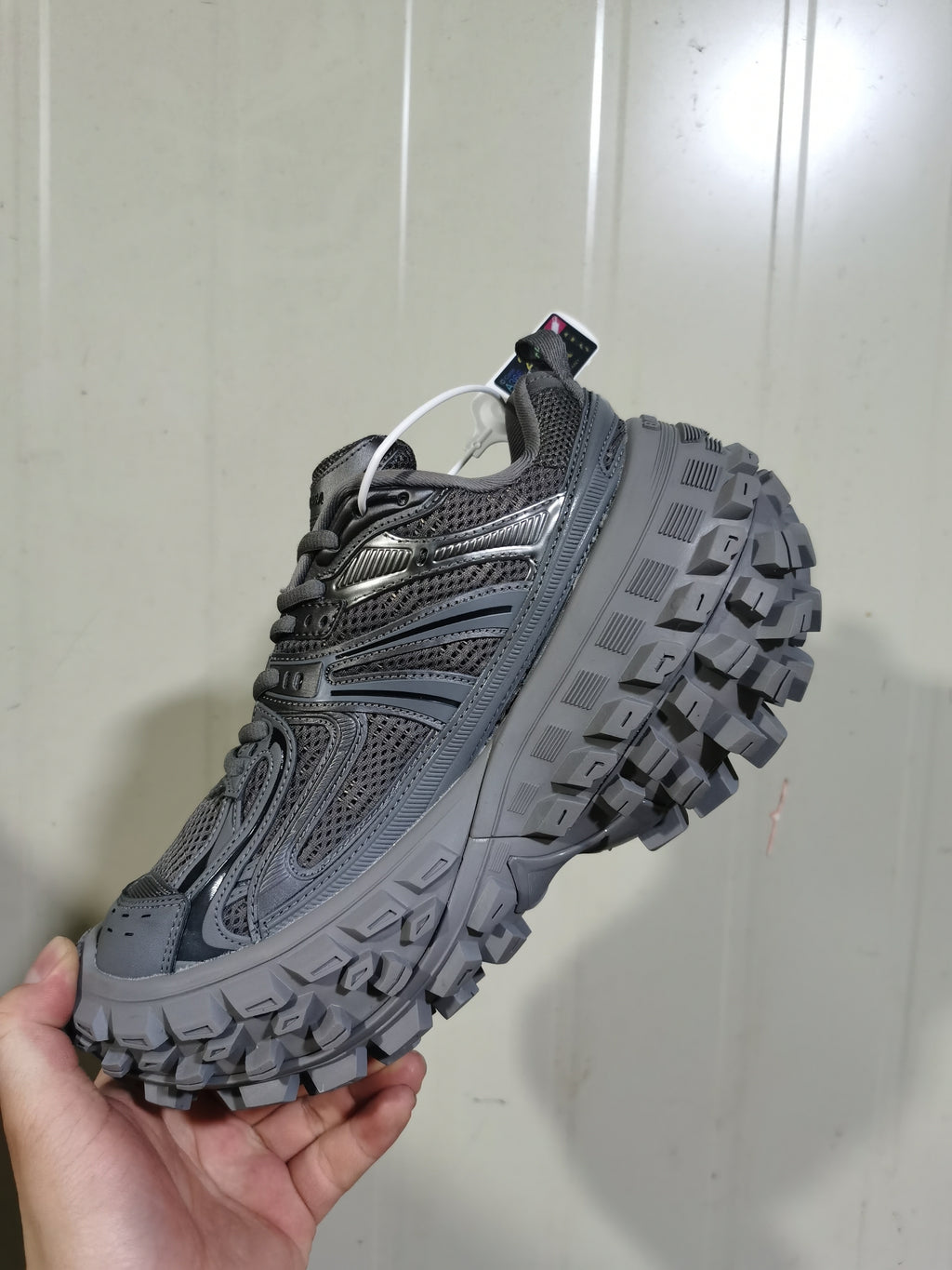 Side view of the dark gray sneaker showing the layered upper, reinforced toe, and large lugged sole.