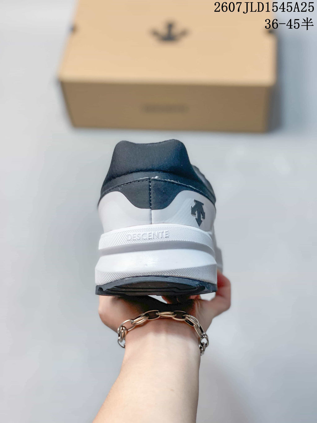 Rear view of the sneaker showing the DESCENTE branding on the white heel section.