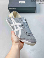 Three-quarter side view showing the gray slip-on sneaker, white side stripes, and rounded toe.