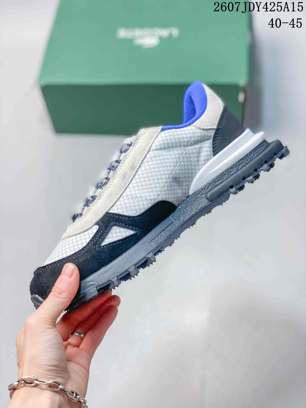 Side profile showing the white textured upper, black overlays, blue collar, and rugged outsole.