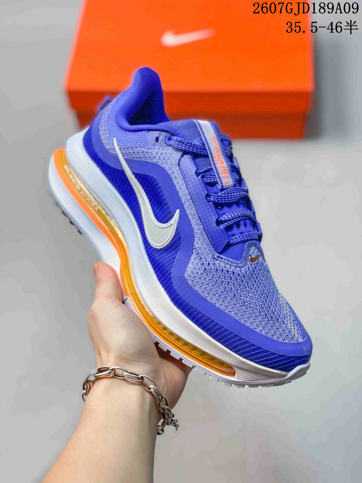 Close side view of the blue Nike Vomero running shoe showing the white Swoosh, textile upper and orange-accented midsole.