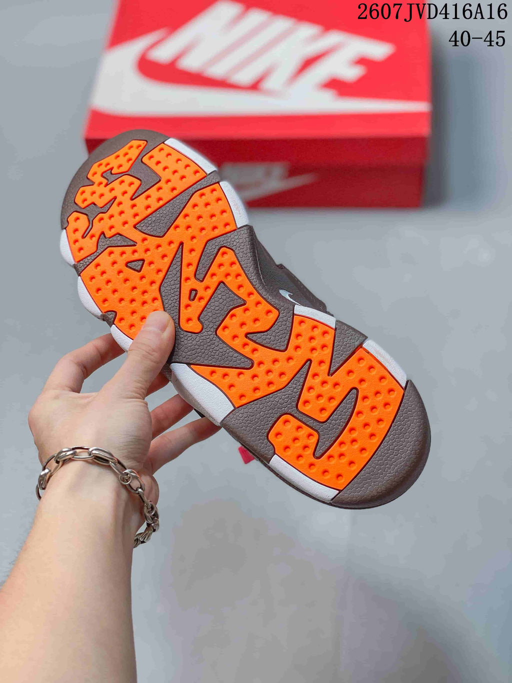 Underside view showing the segmented orange-and-brown outsole with textured tread; image text shows 2607JVD416A16 and 40–45.