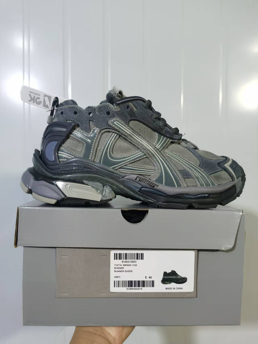Grey Puma 1100 sneaker shown on its box, with the Runner Suede Grey label and sample size E 40 visible.