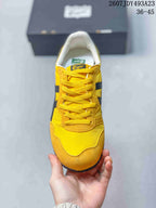 Top view of the yellow lace-up sneaker with black side stripes and contrast stitching.