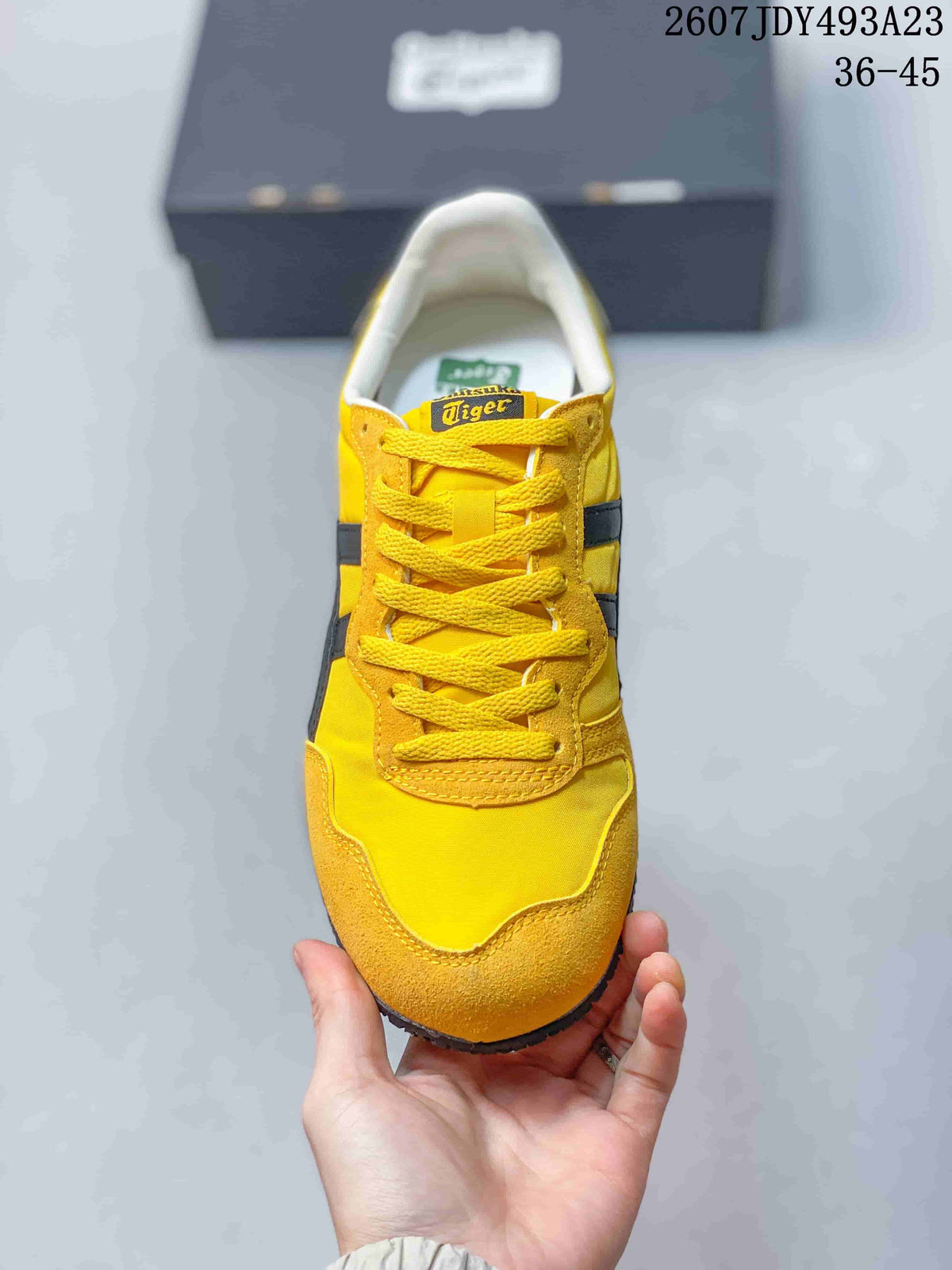 Top view of the yellow lace-up sneaker with black side stripes and contrast stitching.