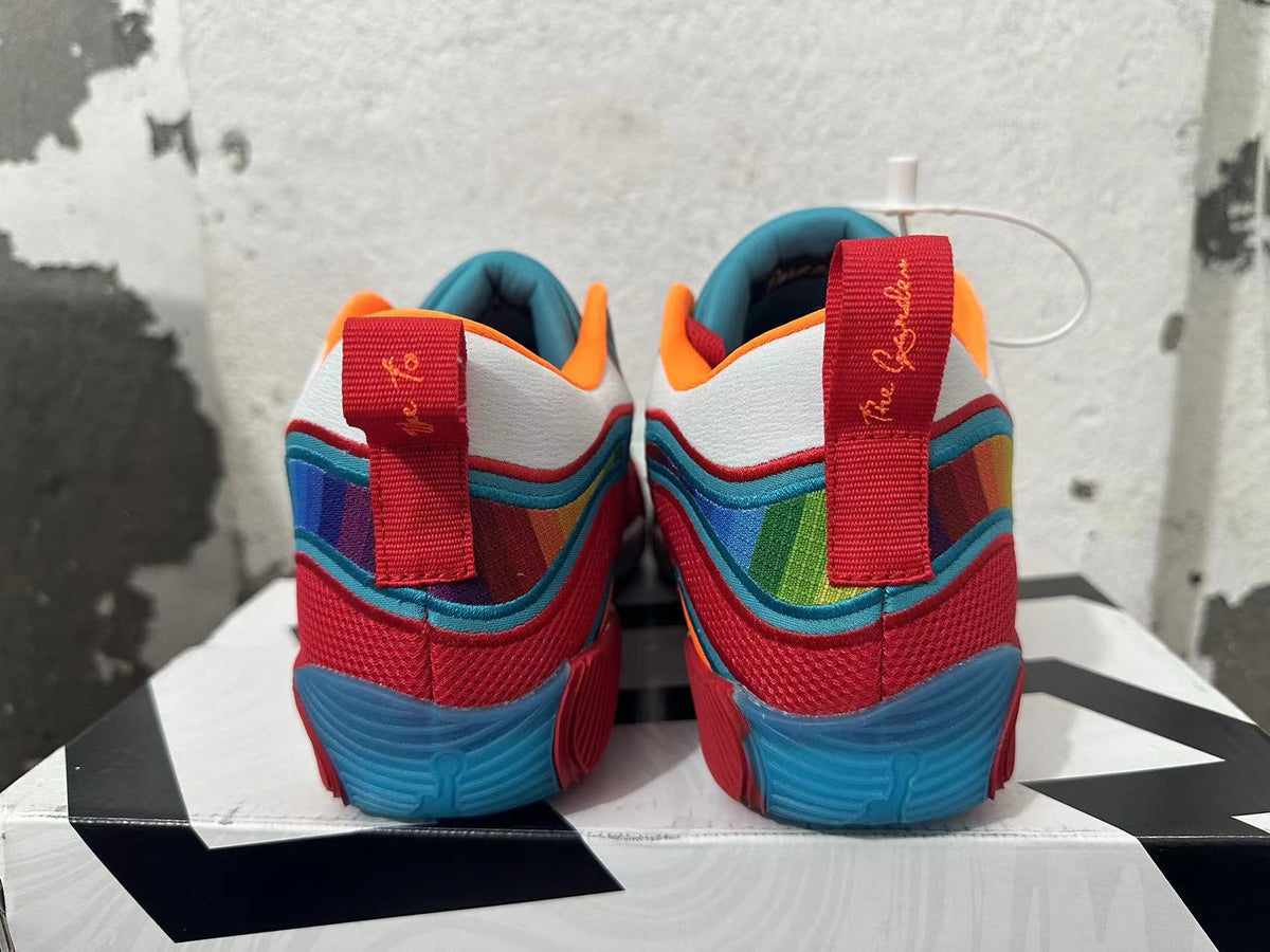 Rear view of red Jordan basketball shoes with blue soles, multicolor panels and heel pull tabs.