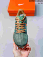 Top view of the green knit-style Nike running shoe with tan laces and orange lace accents.