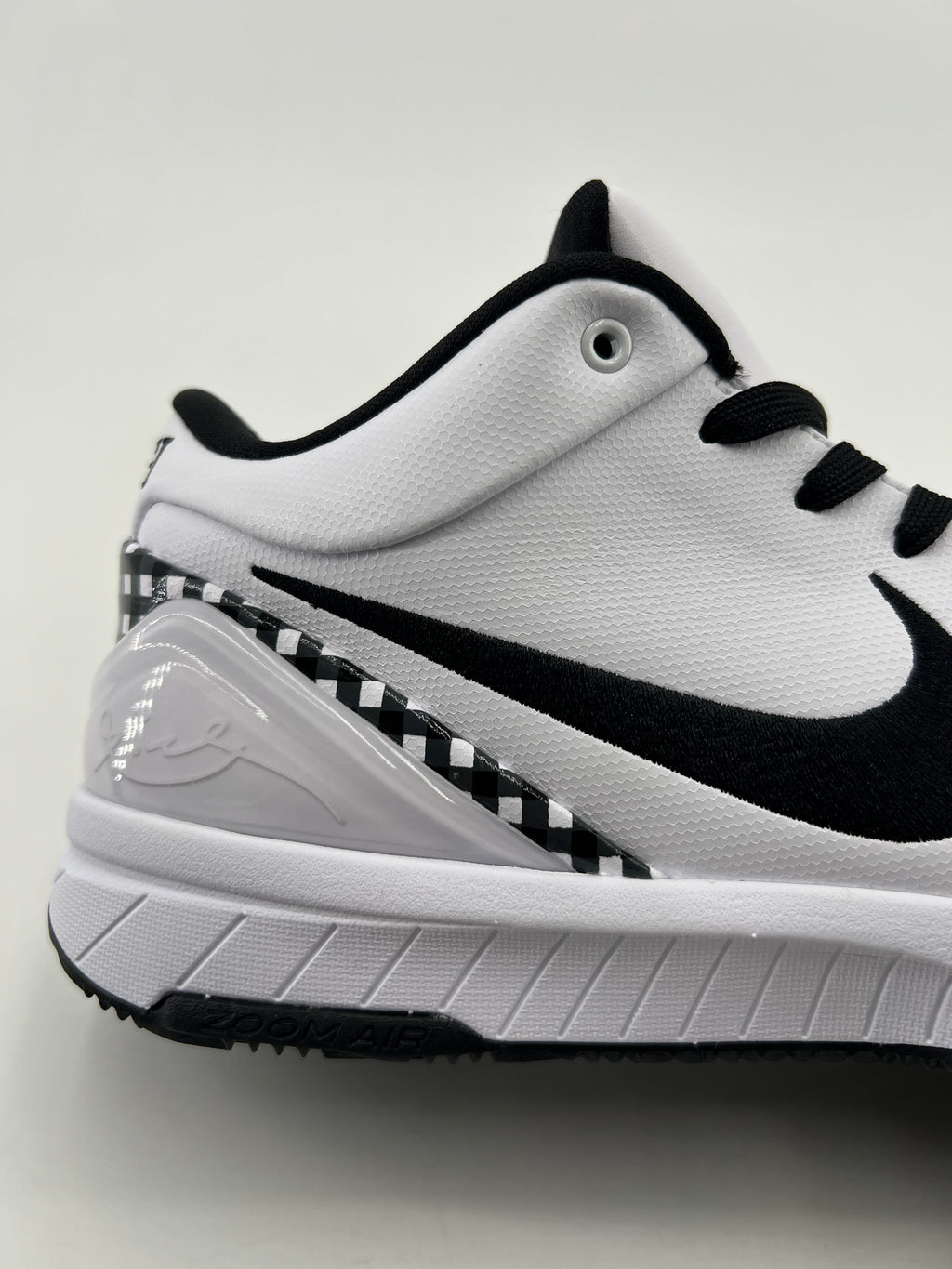Side close-up showing the Swoosh, checkerboard heel trim, and midsole