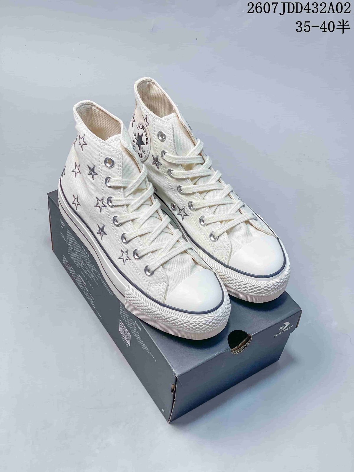 Pair of cream Converse All Star Lift high-top sneakers with embroidered stars and platform-style soles.