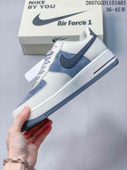Side view of a white and blue-gray low-top sneaker with a contrast Swoosh
