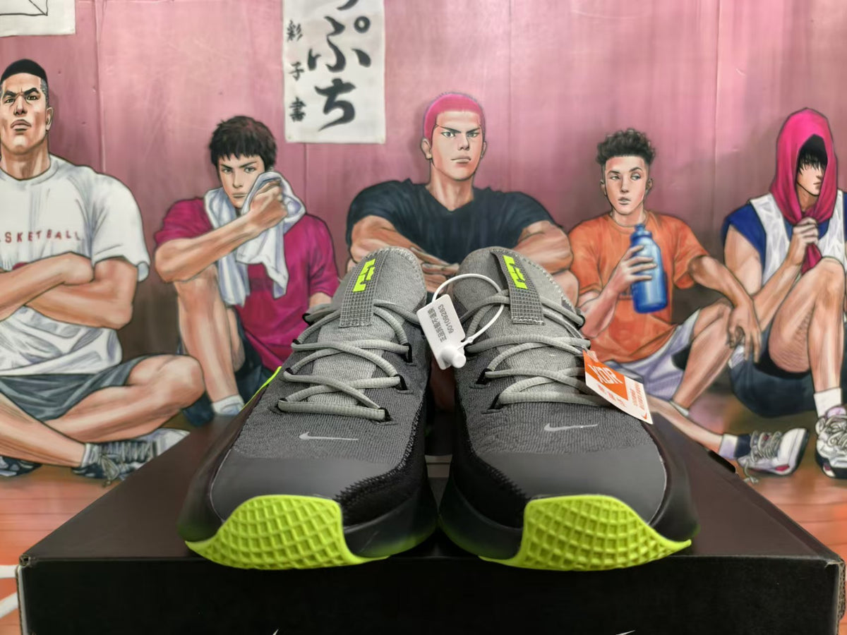 Front view of gray Nike low-top sneakers with black panels and lime-green details