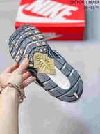 Underside view of a Nike V5 RNR sneaker showing the segmented black, gray and tan outsole tread.