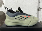 Side view of one green and grey adidas Dame 9 shoe with orange accents and a sculpted sole.